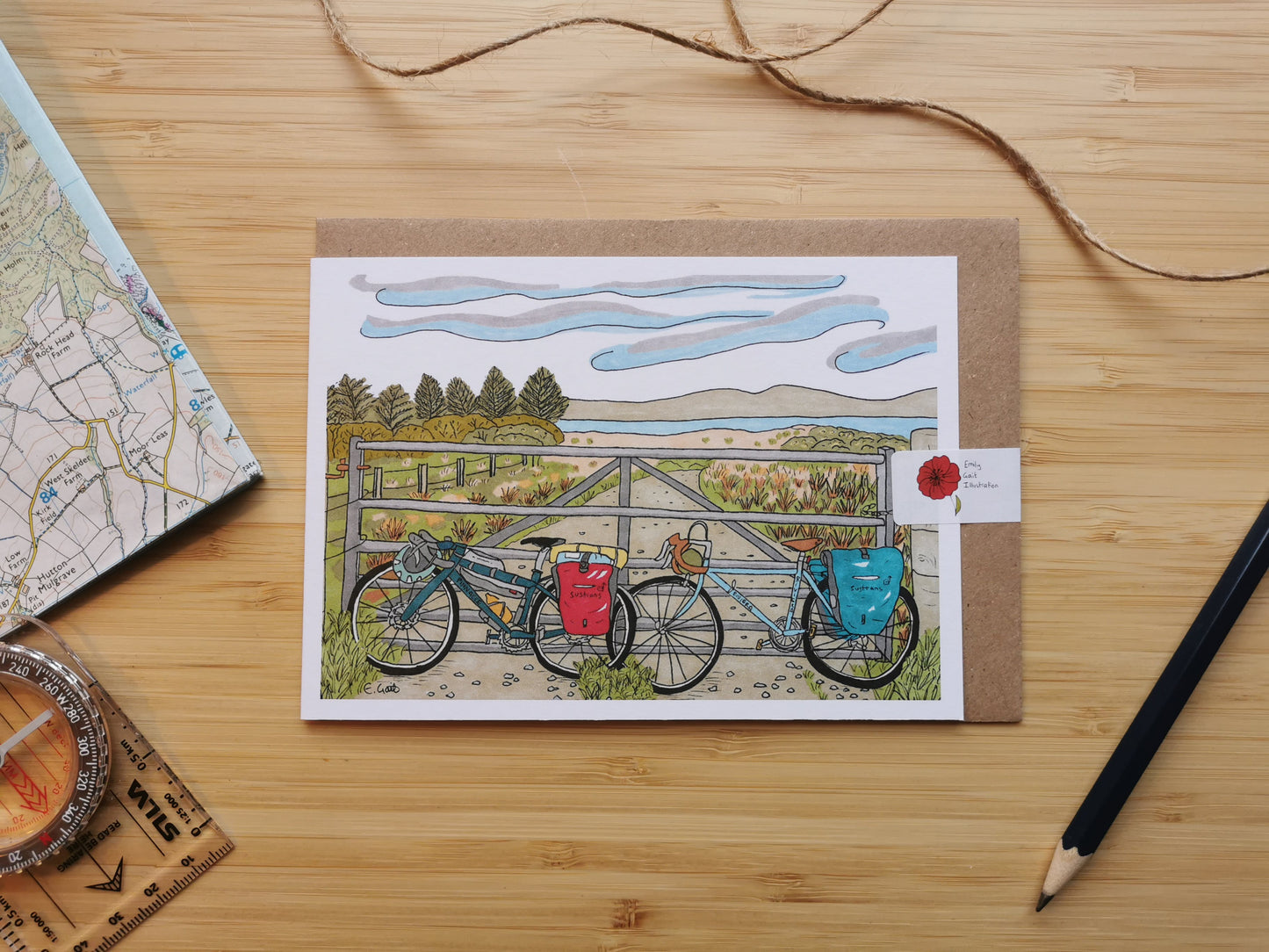 Greeting card with bicycles and a map on a wooden surface