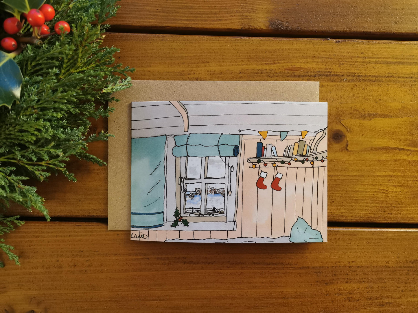 Illustration of inside a shepherds hut or bothy with a view of snowy hills outside through a window. There are also small Christmas stockings. 