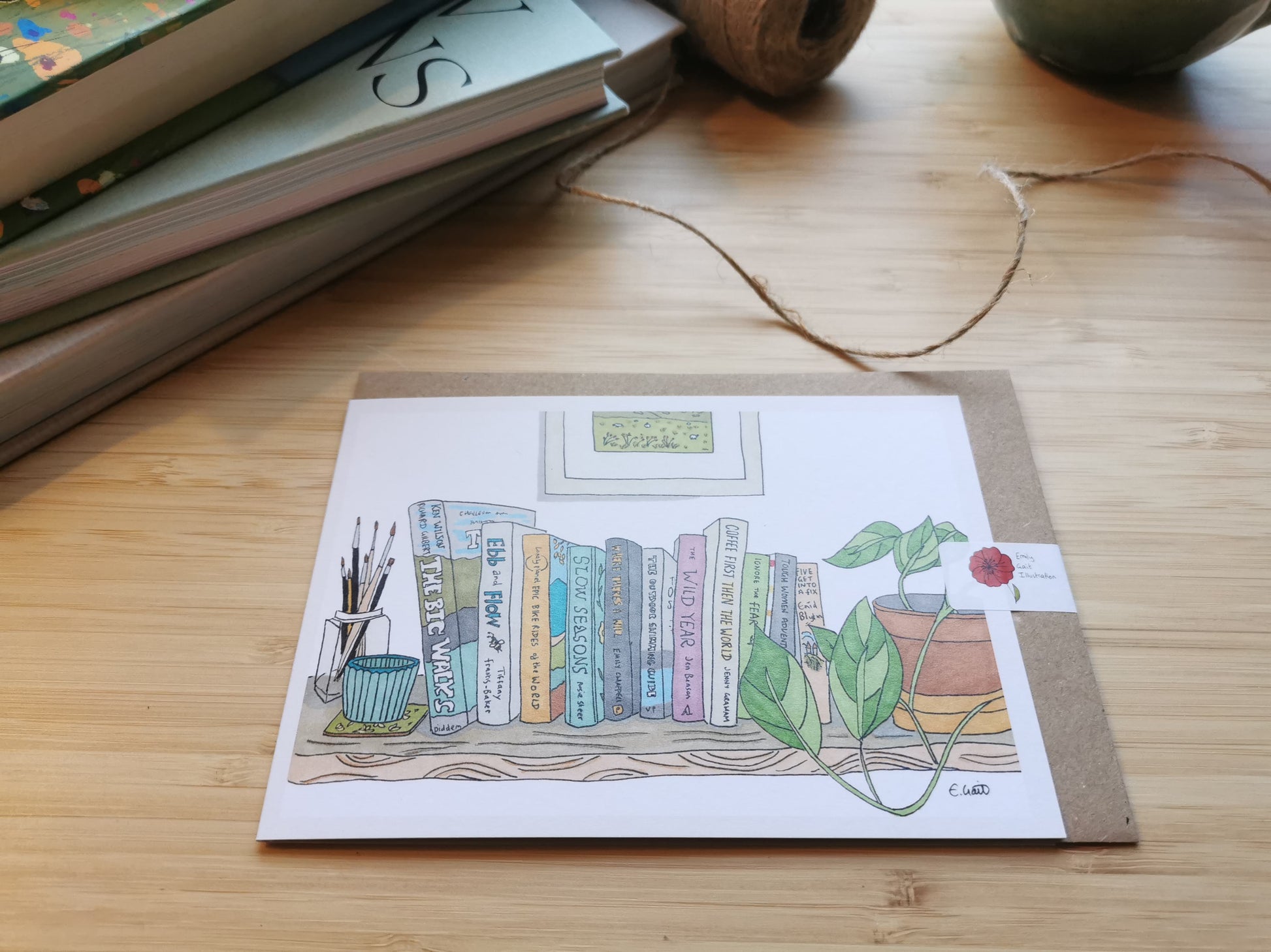 Illustrated card with books relating to adventures and plants on a wooden surface.