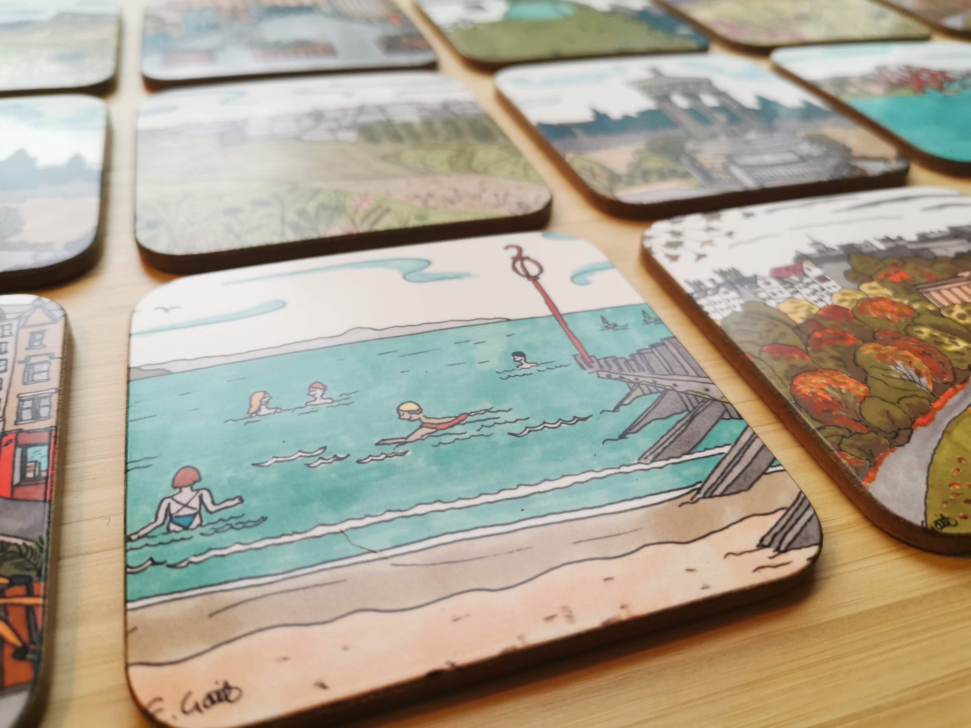 Closeup photo of a set of illustrated coasters on a wooden table.
