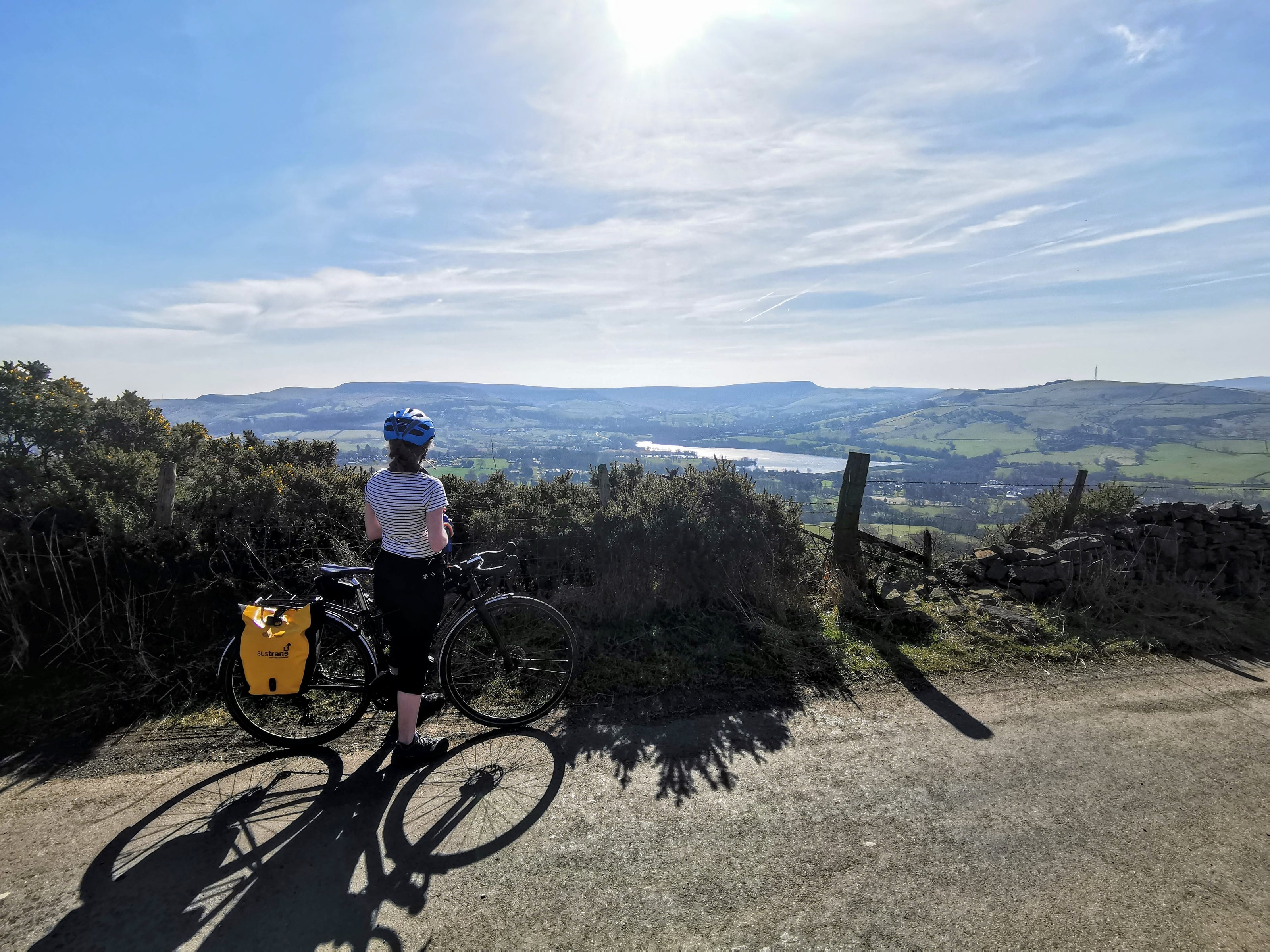 photo of a woman on her bike ride with a landscape and lake in the background.