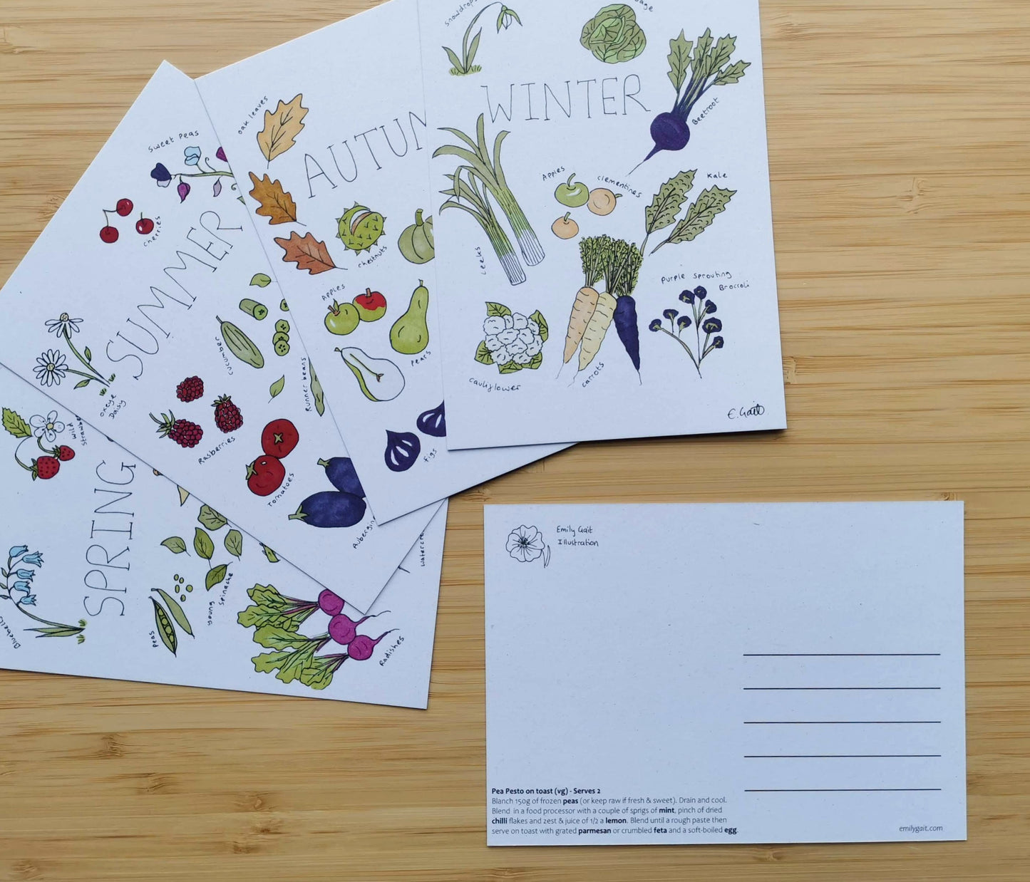 Set of four postcards with seasonal vegetable illustrations and recipes on a wooden surface.