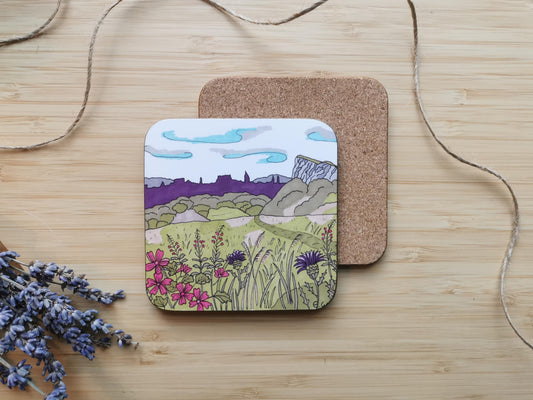 Coaster with design of Salisbury Crags, a view in Edinburgh, on a wooden surface
