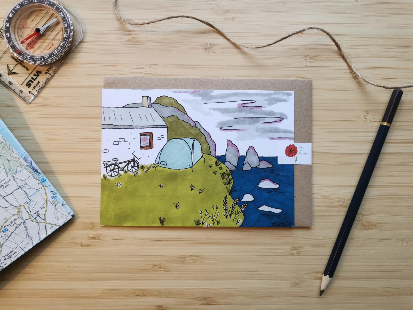 Card with a scenic illustration of a tent outside a cottage or a bothy with a bicycle and the sea nearby.